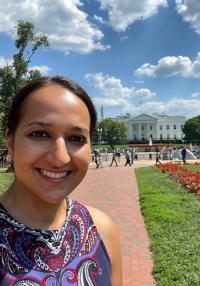 A smiling woman in front of the White House